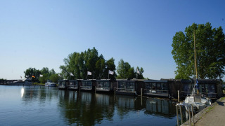 Udsigt over Waterlodge 6 ved Zuiderzee i Holland med flydende hytter og både i rolige omgivelser.