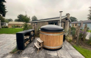Bain à remous en bois avec couvercle noir à Hackfort Hottub 6, Zuiderzee, Pays-Bas, en extérieur.