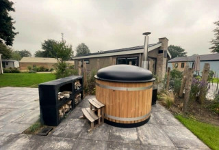 Houten hottub met zwart deksel bij Hackfort Hottub 6 op Zuiderzee, Nederland, buiten op het terras.