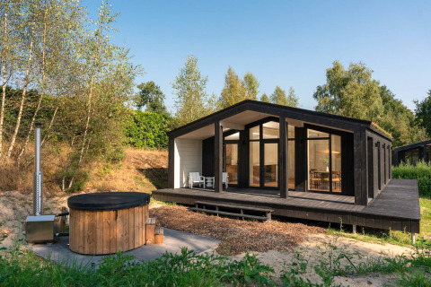 Tiny house Hills moderne avec bain à remous au Wilsumer Berge, Allemagne, entourée de verdure.