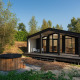 Moderne tiny house ved Wilsumer Berge i Tyskland, med stor terrasse og udendørs vildmarksbad i naturen.