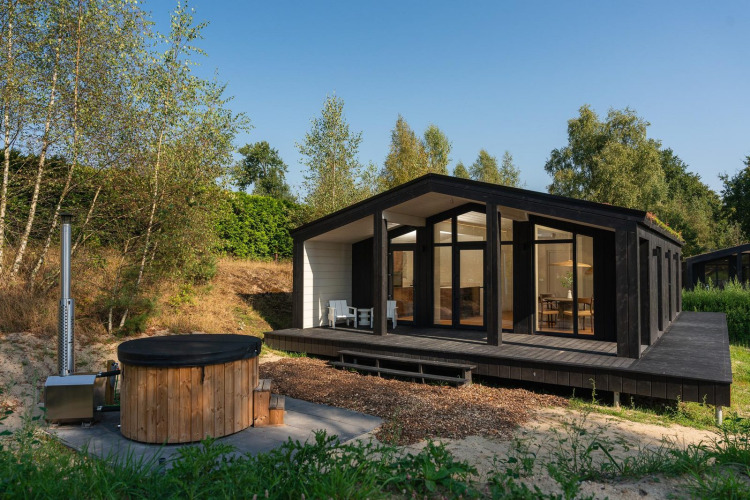 Modern tiny house Hills with hot tub at Wilsumer Berge, Germany, with large deck and nature surroundings.