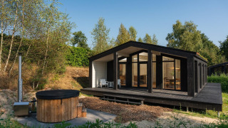 Modernes Tiny House Hills mit Whirlpool am Wilsumer Berge in Deutschland, umgeben von grüner Natur.