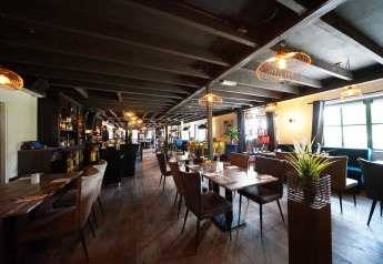 Ristorante accogliente con tavoli in legno e illuminazione moderna in una sistemazione glamping.
