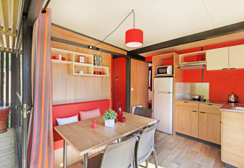 Zona cucina e pranzo moderna nello Chalet Evasion Vista Vue Vignes, Huttopia Meursault, Francia.