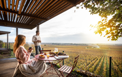 Pareja desayunando en la terraza del Chalet Evasion Vista Vue Vignes con vistas a viñedos en Meursault, Francia.