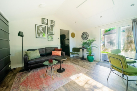 Lichte, moderne woonkamer in lodge Berkel 4 bij De Utrechtse Heuvelrug, Nederland, met groene accenten.