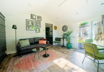 Salon lumineux et moderne au lodge Berkel 4, De Utrechtse Heuvelrug, Pays-Bas, avec accents végétaux.