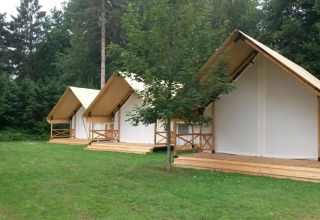Three glamping tents at Glampingtent 6 at De Utrechtse Heuvelrug in the Netherlands, set on grass by trees.
