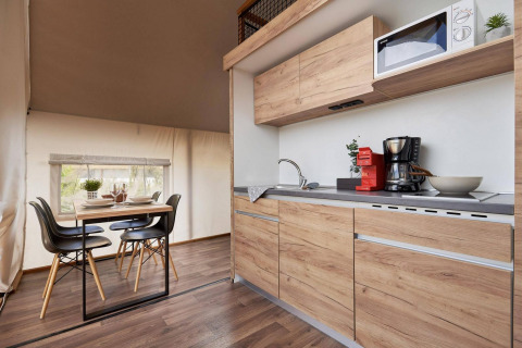 Cocina de tienda glamping moderna y comedor de madera en De Utrechtse Heuvelrug, Países Bajos.