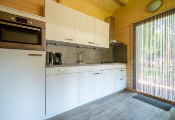 Cucina moderna e compatta nella tiny house Boekhorst 4 a De Utrechtse Heuvelrug, Paesi Bassi, con finiture in legno.