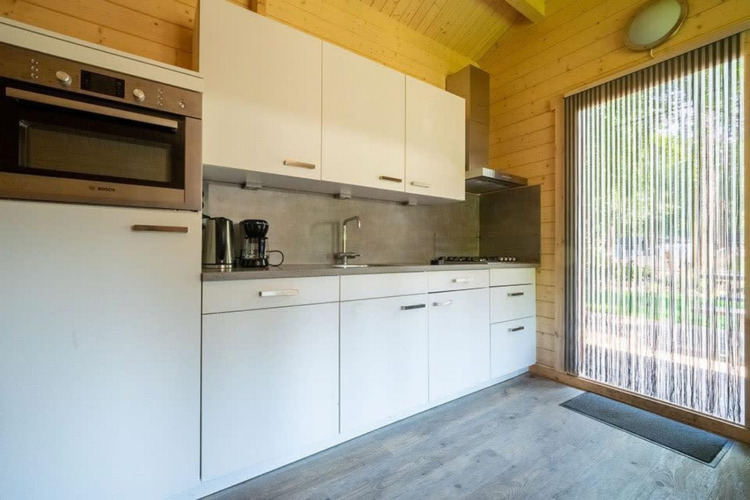 Moderne, compacte keuken in tiny house Boekhorst 4 op De Utrechtse Heuvelrug, Nederland, met houten afwerking.