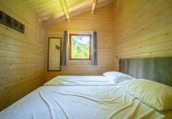 Camera da letto in una tiny house con pareti in legno e due letti singoli, Boekhorst 4, De Utrechtse Heuvelrug, Paesi Bassi.
