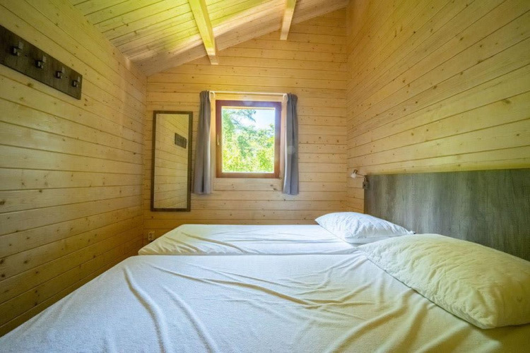 Slaapkamer in een tiny house met houten wanden en twee eenpersoonsbedden, Boekhorst 4, De Utrechtse Heuvelrug, Nederland.