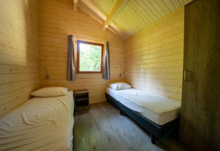 Twee eenpersoonsbedden in een houten tiny house met venster, Boekhorst 4, De Utrechtse Heuvelrug, Nederland.