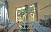 Salón moderno en Panorama Cottage 4 en De Utrechtse Heuvelrug, Países Bajos, con vistas al jardín exterior.