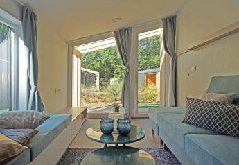 Salón moderno en Panorama Cottage 4 en De Utrechtse Heuvelrug, Países Bajos, con vistas al jardín exterior.