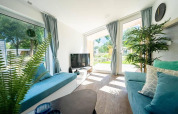 Sala luminosa en Panorama Cottage 4 con grandes ventanales, decoración moderna y vistas verdes en los Países Bajos.