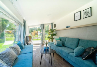 Sala luminosa de Panorama Cottage 4 en De Utrechtse Heuvelrug, Países Bajos, con vista al jardín.