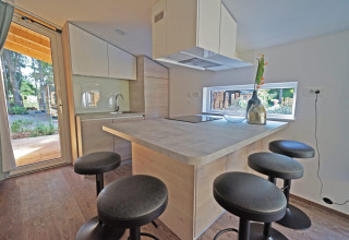 Cocina moderna de lodge con taburetes altos y ventanas grandes en Panorama Cottage 4, De Utrechtse Heuvelrug, Países Bajos.