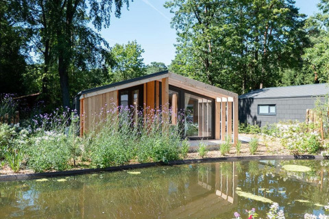 Moderne lodge ved navn Panorama Cottage 4 ved De Utrechtse Heuvelrug i Holland, omgivet af natur og dam.