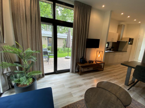Moderne opholdsstue i Pavilion 6 på De Utrechtse Heuvelrug, Holland, med udsigt til terrasse og have.