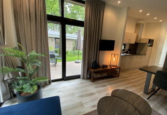 Modernes Wohnzimmer im Pavilion 6 in De Utrechtse Heuvelrug, Niederlande, mit Blick auf Terrasse und Garten.