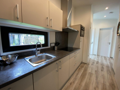 Cocina moderna en el Pavilion 6 de De Utrechtse Heuvelrug, Países Bajos, con suelo de madera y ventana.