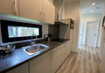 Moderne Küche in Pavillon 6 bei De Utrechtse Heuvelrug, Niederlande, mit Fenster und Holzfußboden.