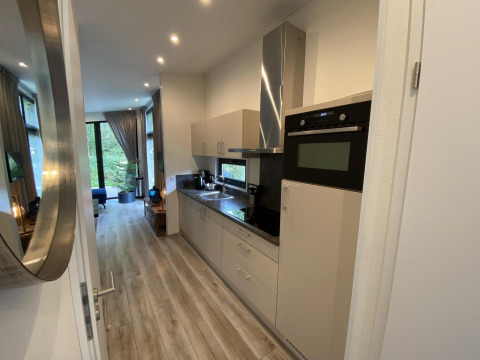 Cocina moderna y zona de estar en el Pabellón 6 del lodge De Utrechtse Heuvelrug en los Países Bajos.