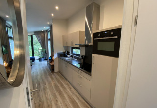 Cocina moderna y zona de estar en el Pabellón 6 del lodge De Utrechtse Heuvelrug en los Países Bajos.