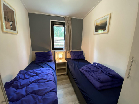 Dos camas individuales con ropa de cama azul en Pavilion 6, De Utrechtse Heuvelrug, Países Bajos.