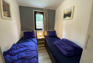 Dos camas individuales con ropa de cama azul en Pavilion 6, De Utrechtse Heuvelrug, Países Bajos.