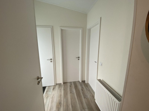 Pasillo con tres puertas blancas y suelo de madera en el Pabellón 6 de De Utrechtse Heuvelrug, Países Bajos.