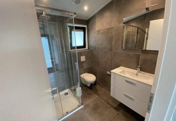 Moderne badkamer in Pavilion 6 bij De Utrechtse Heuvelrug in Nederland met douche en zwevend toilet.