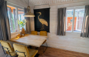 Acogedor comedor en Stuga 4 de De Utrechtse Heuvelrug, Países Bajos, con mesa de madera y decoración natural.