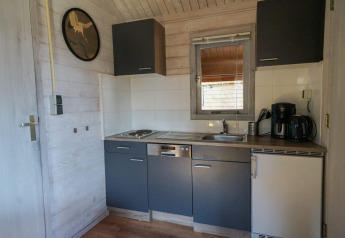 Pequeña cocina en Stuga 4 de De Utrechtse Heuvelrug, Países Bajos, con fregadero, vitrocerámica y cafetera.