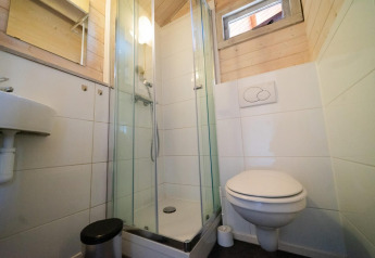 Bagno compatto con cabina doccia, lavabo e WC sospeso in Stuga 4, De Utrechtse Heuvelrug, Paesi Bassi.