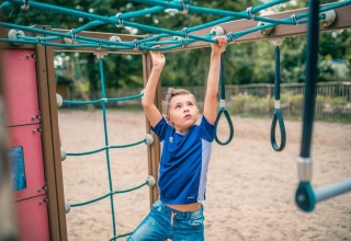 Niño juega en equipo de escalada al aire libre en Tiny House 4, De Utrechtse Heuvelrug, Países Bajos.