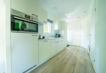 Moderne witte keuken met oven en koffiezet in Velthorst 4, De Utrechtse Heuvelrug, Nederland.