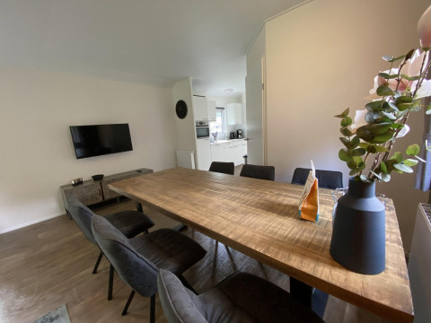 Salle à manger moderne avec table en bois et six chaises dans le lodge Velthorst 6 à De Utrechtse Heuvelrug, Pays-Bas.