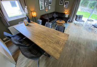 Moderne lodge Velthorst 6 op De Utrechtse Heuvelrug, Nederland, met eettafel en gezellige zithoek.