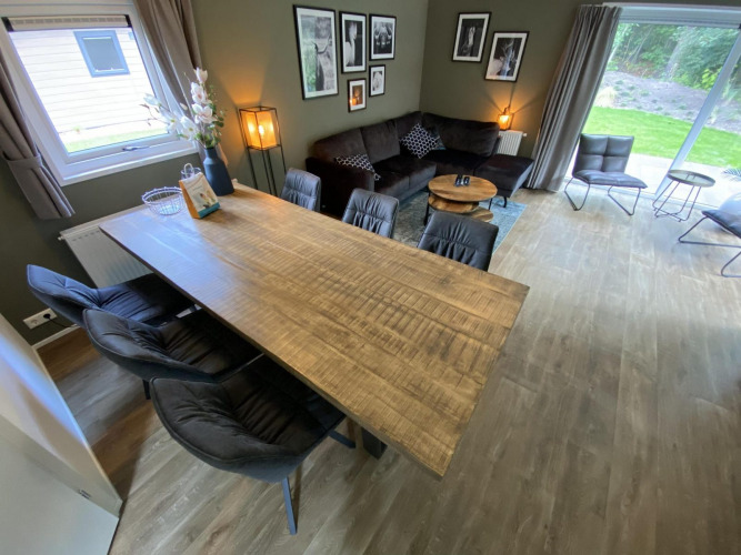 Moderne Lodge Velthorst 6 in De Utrechtse Heuvelrug, Niederlande, mit großem Holztisch und Wohnzimmer.