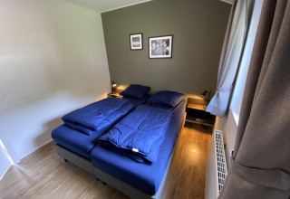 Slaapkamer in Velthorst 6 met twee eenpersoonsbedden, blauwe dekens en moderne stijl in Utrechtse Heuvelrug.