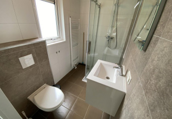 Salle de bain moderne compacte au lodge Velthorst 6 avec douche, lavabo et WC à De Utrechtse Heuvelrug, Pays-Bas.