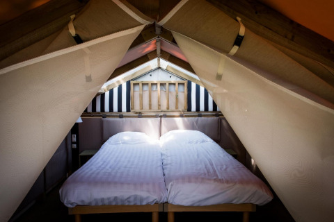 Zona de dormitorio en Air Lodge en Hoge Kempen, Bélgica, con dos camas individuales en una tienda de campaña.