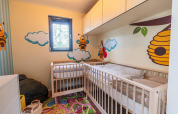 Cameretta colorata con culle e decorazioni di api nel Baby cottage, Hoge Kempen, Belgio.