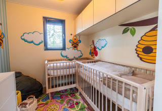Colorful nursery in Baby cottage with cribs, bee and cloud wall art, at Hoge Kempen, Belgium.