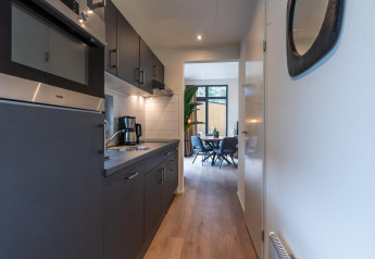 Cucina moderna e zona pranzo nel Baby Cottage, tiny house a Hoge Kempen, Belgio.