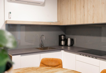 Moderne kitchenette in het Belsano-lodge aan Hoge Kempen met koffiemachine en houten kasten.
